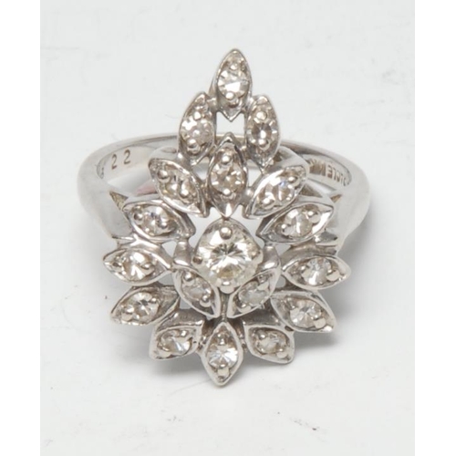 395 - An Art Deco diamond cluster ring, the pear shaped fan crest inset with eighteen old brilliant cut di... 