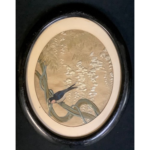 556 - A 19th century Japanese silk embroidery, Swallow amongst Wisteria, ebonised oval frame, 44cm x 36cm