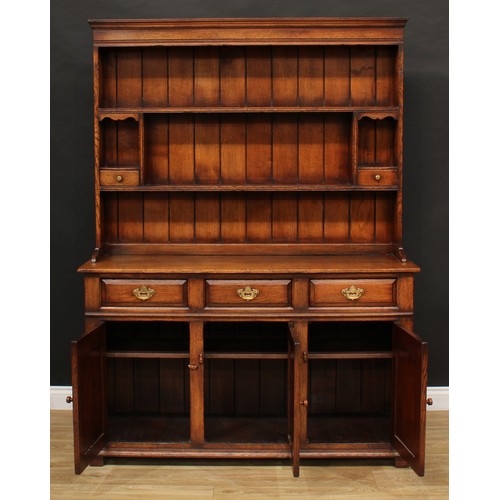 102 - A Titchmarsh & Goodwin oak dresser, moulded cornice above a pair of plate racks, the lower flanked b... 