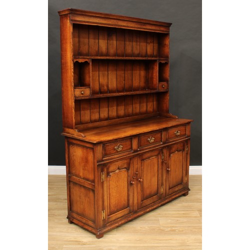 102 - A Titchmarsh & Goodwin oak dresser, moulded cornice above a pair of plate racks, the lower flanked b... 