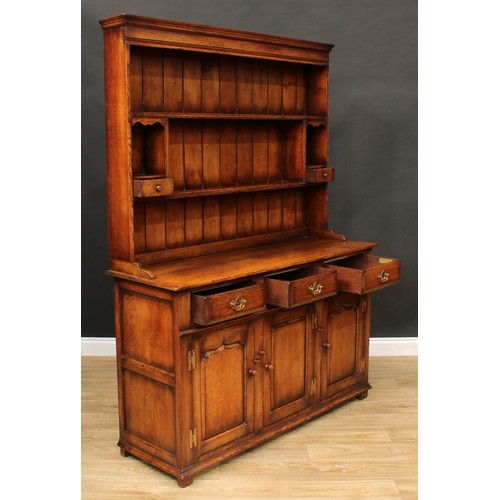 102 - A Titchmarsh & Goodwin oak dresser, moulded cornice above a pair of plate racks, the lower flanked b... 