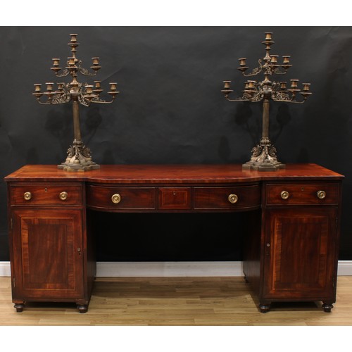 110 - A Regency mahogany bow-centre sideboard, crossbanded top above a central frieze drawer, each pedesta... 