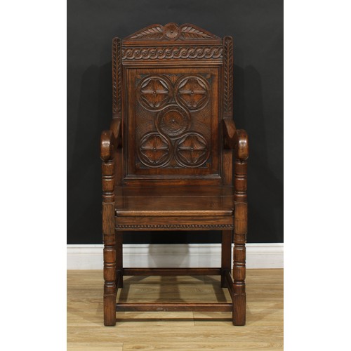 117 - A 17th century style oak Wainscot armchair, rectangular panel back carved with flowerhead bosses, 11... 