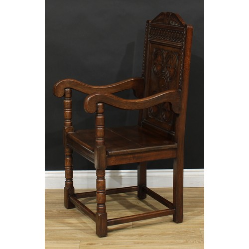 117 - A 17th century style oak Wainscot armchair, rectangular panel back carved with flowerhead bosses, 11... 