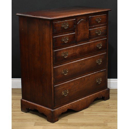 215 - An oak chest, rectangular top, four short drawers centred by an arched cupboard door above three lon... 