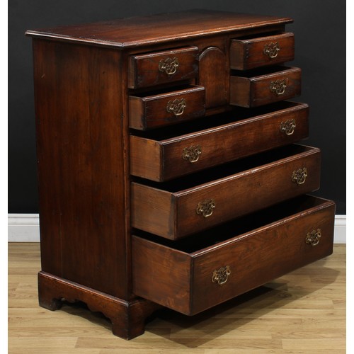 215 - An oak chest, rectangular top, four short drawers centred by an arched cupboard door above three lon... 