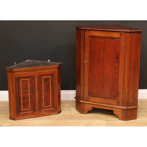 542 - A Sheraton inspired satinwood banded mahogany wall hanging splay front corner cupboard, of small pro... 