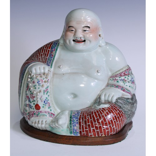 5120 - A Chinese porcelain model, of Budai, seated, smiling, brightly painted in polychrome enamels, 29cm h... 