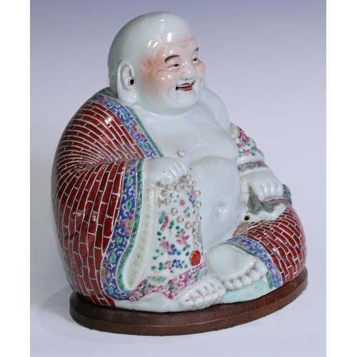 5120 - A Chinese porcelain model, of Budai, seated, smiling, brightly painted in polychrome enamels, 29cm h... 