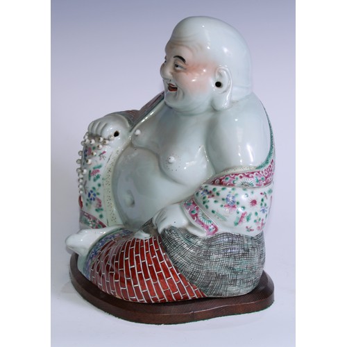 5120 - A Chinese porcelain model, of Budai, seated, smiling, brightly painted in polychrome enamels, 29cm h... 