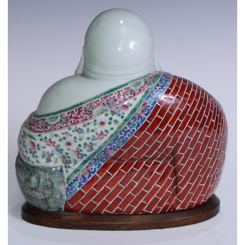 5120 - A Chinese porcelain model, of Budai, seated, smiling, brightly painted in polychrome enamels, 29cm h... 