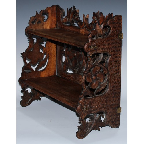 5080 - A Black Forest table-top two-shelf bookcase, the hinged sides restrained by hook-and-loops, carved i... 