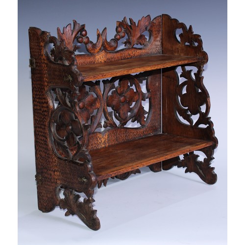 5080 - A Black Forest table-top two-shelf bookcase, the hinged sides restrained by hook-and-loops, carved i... 