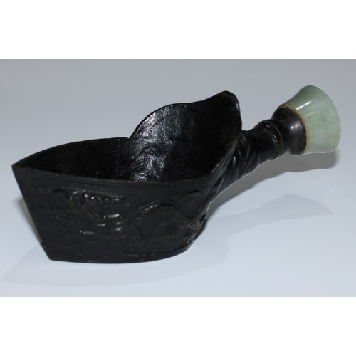 5117 - A Chinese pan form silk iron, cast with dragons, bronze base, jade handle, 16cm long