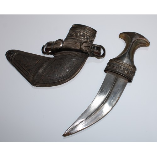 5655 - A Middle Eastern silver mounted jambiya dagger, 17cm curved blade with central ridge, horn grip, the... 