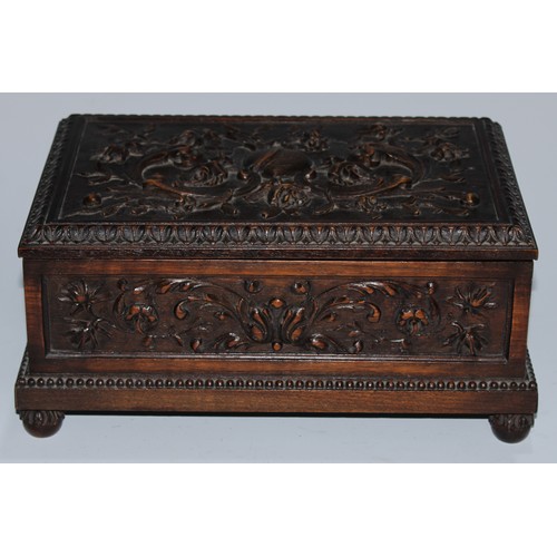 5217 - A near pair of Carolean Revival oak rectangular table-top caskets, the hinged covers boldly carved i... 