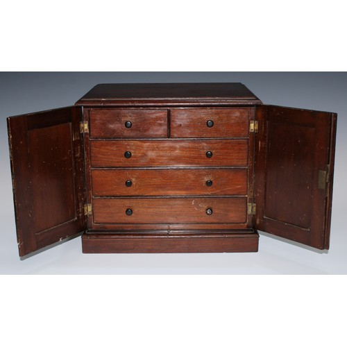 5069 - A 19th century table cabinet, moulded oversailing top above a pair of panelled doors enclosing two s... 