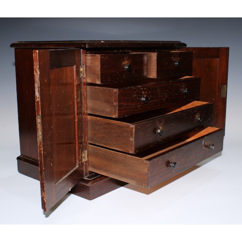 5069 - A 19th century table cabinet, moulded oversailing top above a pair of panelled doors enclosing two s... 