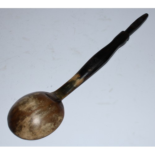 5166 - A horn spoon or ladle, the handle carved with a stylised face, 30.5cm long