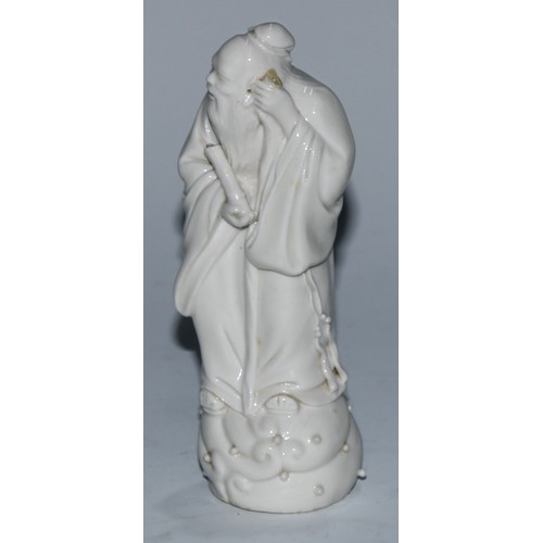 5097 - A Chinese blanc de chine figure, of an immortal holding a scroll, 14.5cm high