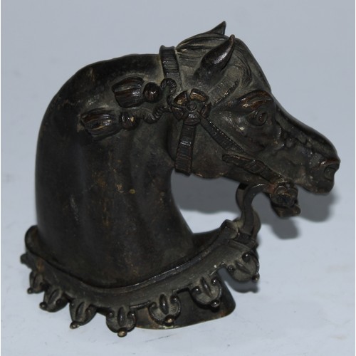 5086 - A bronze mount, probably from a sword hilt, cast as the head of a horse, 8.5cm long