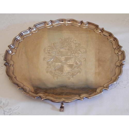 175 - A silver George III style tray, engraved and chased with coat of arms, three scroll feet, 30cm diam,... 