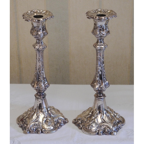182 - A pair of plated candlesticks, detachable nozzles, panelled campana shaped sconces, the bases cast w... 
