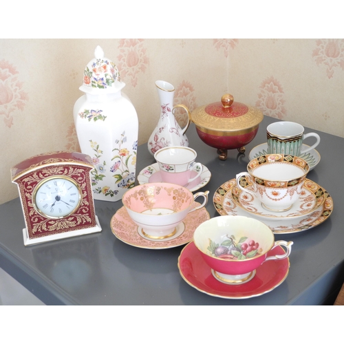 22 - A Paragon cabinet cup and saucer, printed with colourful flowers, on a pink ground;  another, with r... 