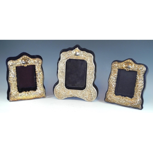 299 - A Victorian style easel photograph frame of arched rectangular form embossed with cherubs, foliate s... 