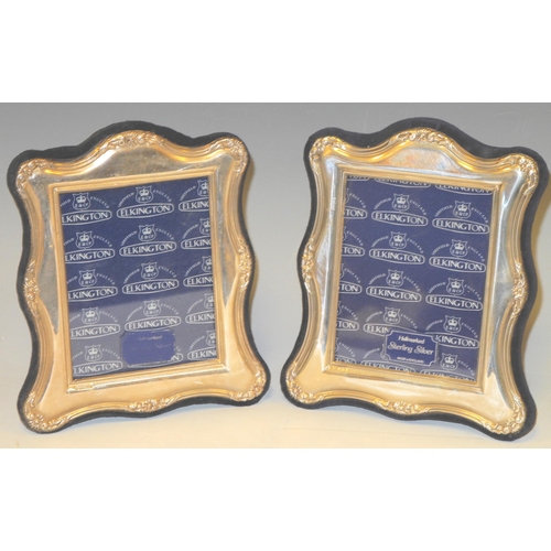 312 - A pair of silver easel photograph frames of arched rectangular form, embossed with leaf wrapped reed... 