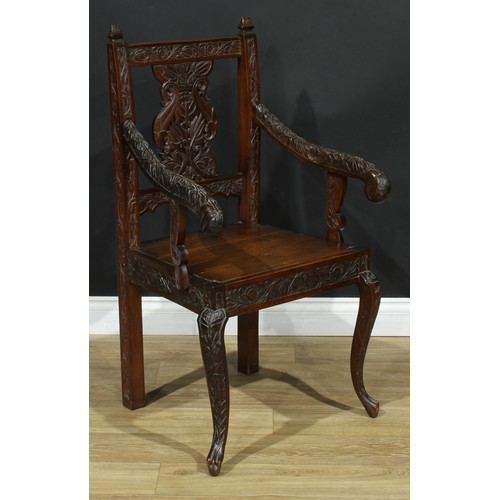 115 - An Anglo-Indian design open armchair, carved throughout with flowers and leaves, cabriole forelegs, ... 