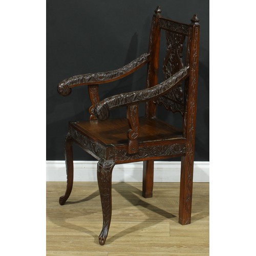 115 - An Anglo-Indian design open armchair, carved throughout with flowers and leaves, cabriole forelegs, ... 