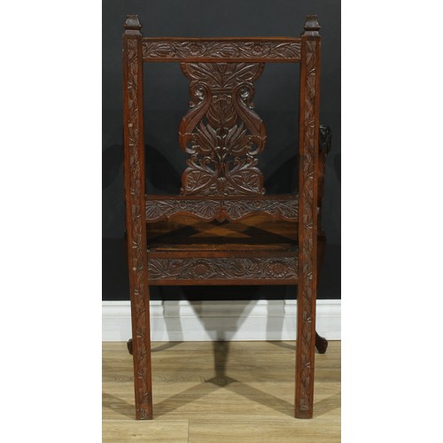 115 - An Anglo-Indian design open armchair, carved throughout with flowers and leaves, cabriole forelegs, ... 