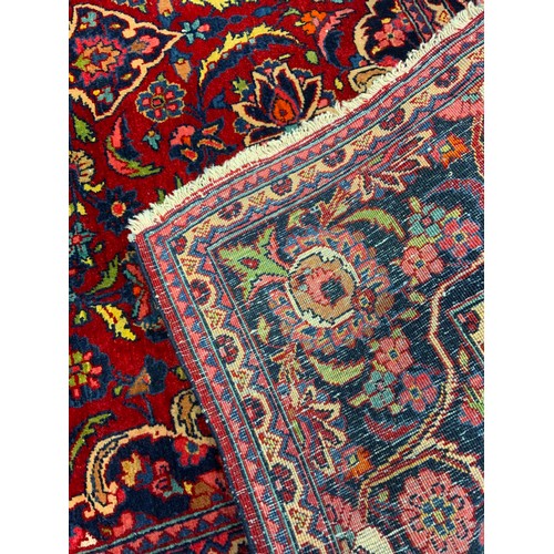 29 - An antique, hand-made, Persian Kashan rug / carpet, woven in tones of deep red and blue, 202cm x 130... 