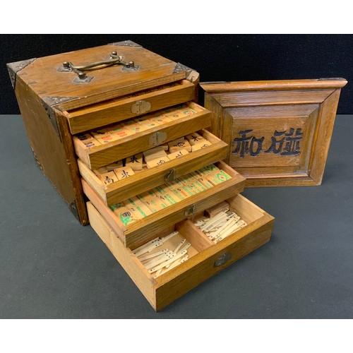 128 - A Chinese Mah-Jong set, boxwood tiles, the oak cabinet with five drawers, measuring 18.5cm x 21.5cm ... 
