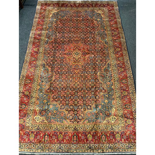 145 - A fine Persian Tabriz rug / carpet, woven in shades of red, pale blue, and indigo, 350cm x 215cm.