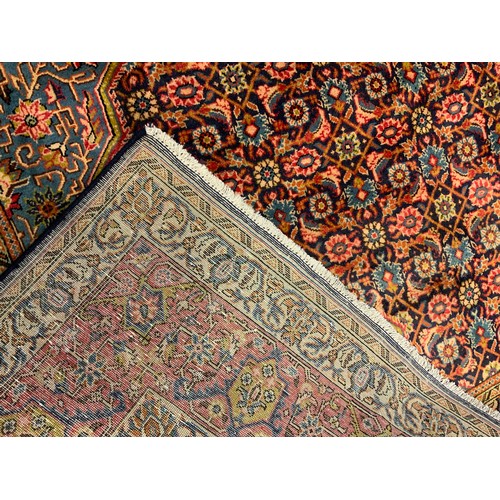 145 - A fine Persian Tabriz rug / carpet, woven in shades of red, pale blue, and indigo, 350cm x 215cm.
