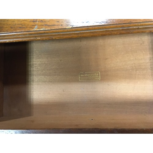 147 - A mid 20th century oak veneered bedroom suite by Austinsuite, comprising two double wardrobes and a ... 