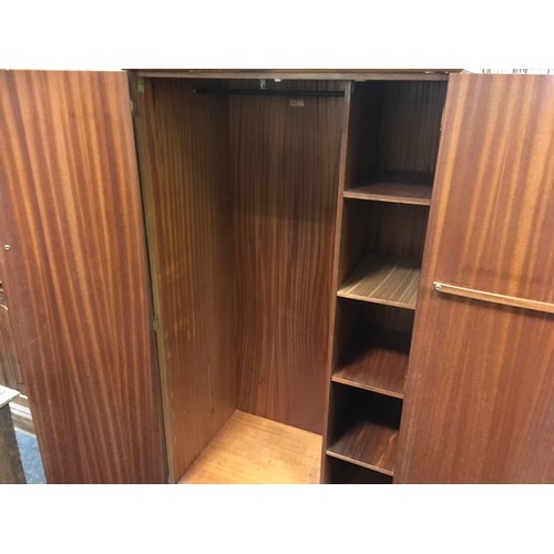 147 - A mid 20th century oak veneered bedroom suite by Austinsuite, comprising two double wardrobes and a ... 