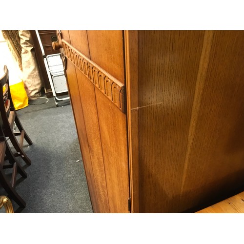 147 - A mid 20th century oak veneered bedroom suite by Austinsuite, comprising two double wardrobes and a ... 