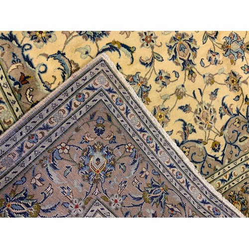 20 - A fine Kashan rug / carpet, woven in muted tones of grey, blue, and cream, 310cm x 205cm.