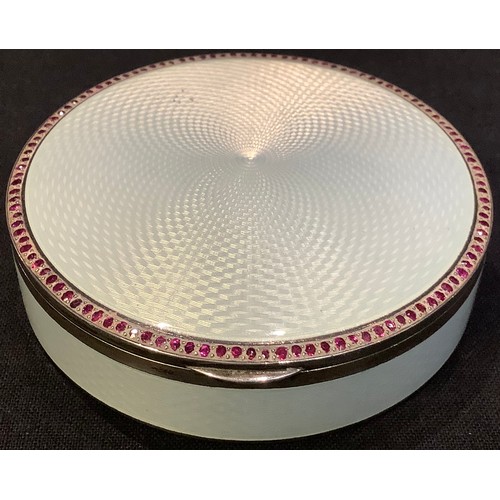 67 - An early 20th century silver and guilloche enamel circular box, the cover border set imitating rubie... 