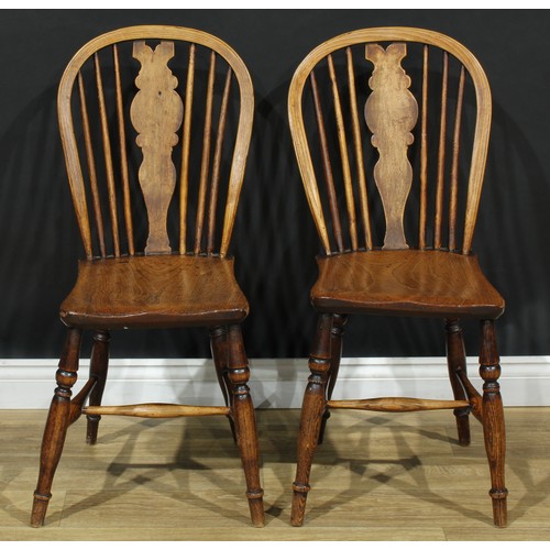 17 - A pair of 19th century Windsor-form side chairs, each with a hoop back, shaped splat, saddle seat, t... 