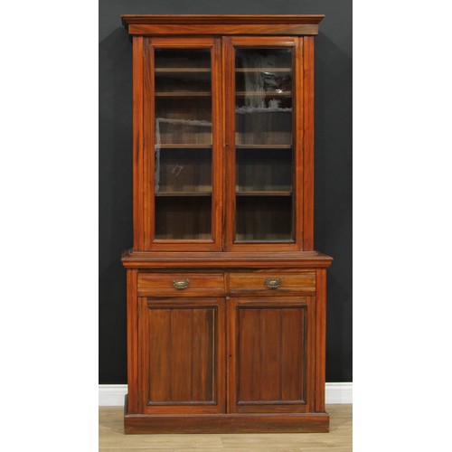 107 - A late Victorian/Edwardian library bookcase, moulded cornice above a pair of glazed doors enclosing ... 