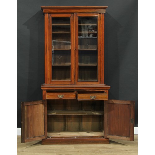 107 - A late Victorian/Edwardian library bookcase, moulded cornice above a pair of glazed doors enclosing ... 