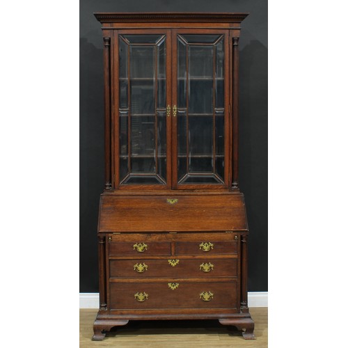 109 - A George III Revival oak bureau bookcase, moulded cornice with dentil capital above a pair of glazed... 