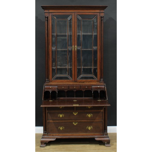 109 - A George III Revival oak bureau bookcase, moulded cornice with dentil capital above a pair of glazed... 