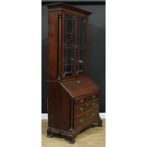 109 - A George III Revival oak bureau bookcase, moulded cornice with dentil capital above a pair of glazed... 