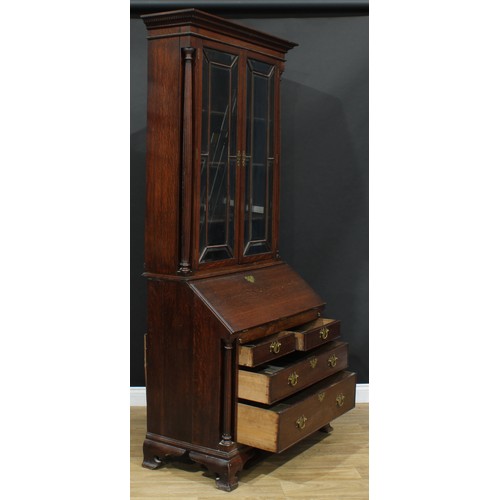 109 - A George III Revival oak bureau bookcase, moulded cornice with dentil capital above a pair of glazed... 