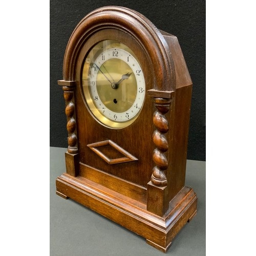 102 - An early 20th century oak mantel clock, Arabic numerals,, the arched case with turned columns, 38cm ... 